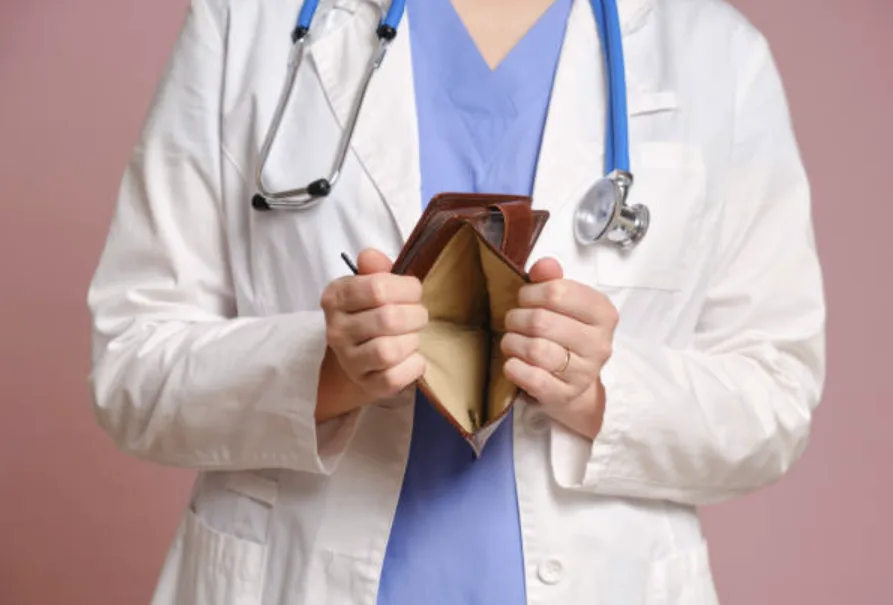 Médecin en blouse tenant un portefeuille ouvert et vide